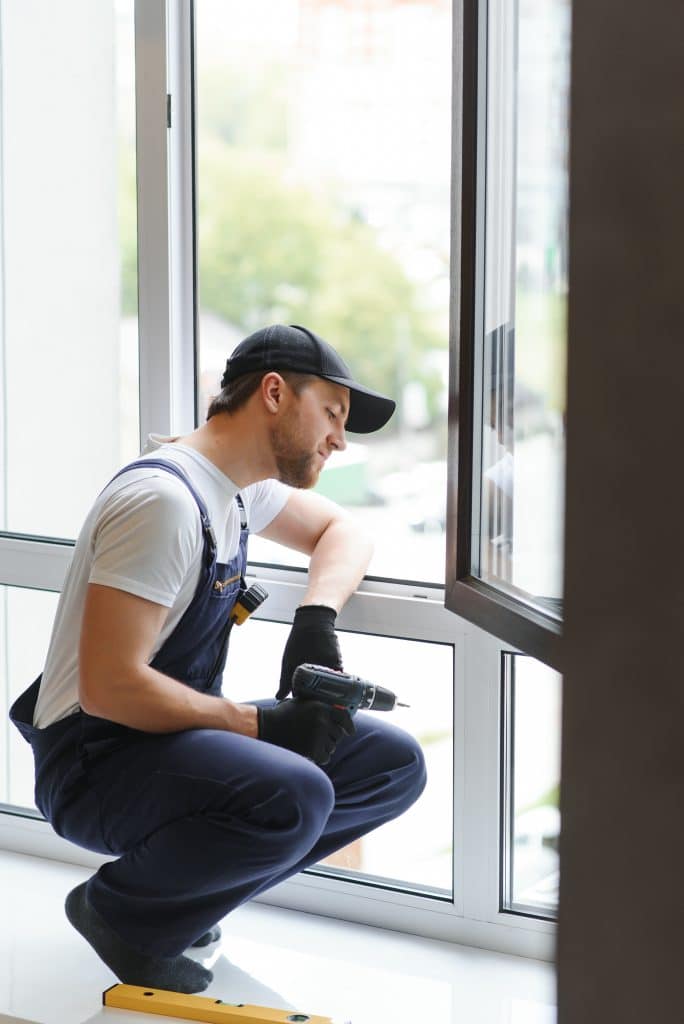 service man installing window with measure tape 2023 11 27 05 30 44 utc