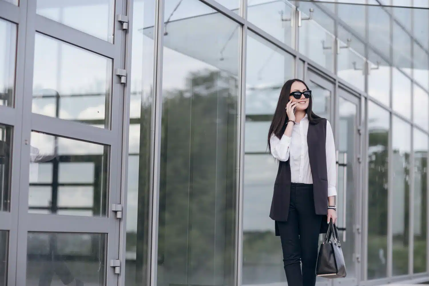 Woman walking in front of commercial glass