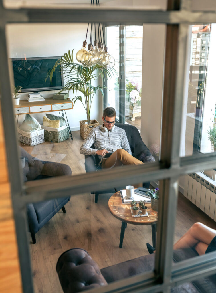 Man relaxing in front of a glass wall